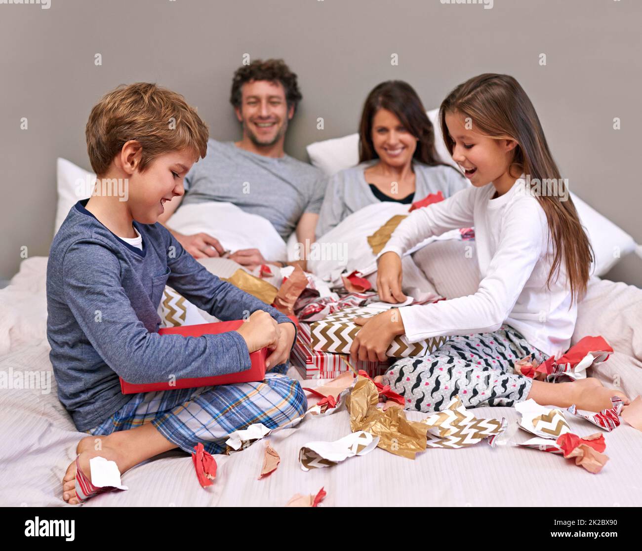 Zeit mit der Familie. Aufnahme einer glücklichen vierköpfigen Familie im Schlafzimmer. Stockfoto
