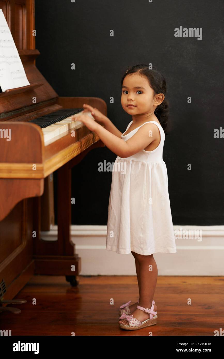 Virtuos im Bilden. Eine kleine Aufnahme eines kleinen Mädchens, das Klavier spielt. Stockfoto