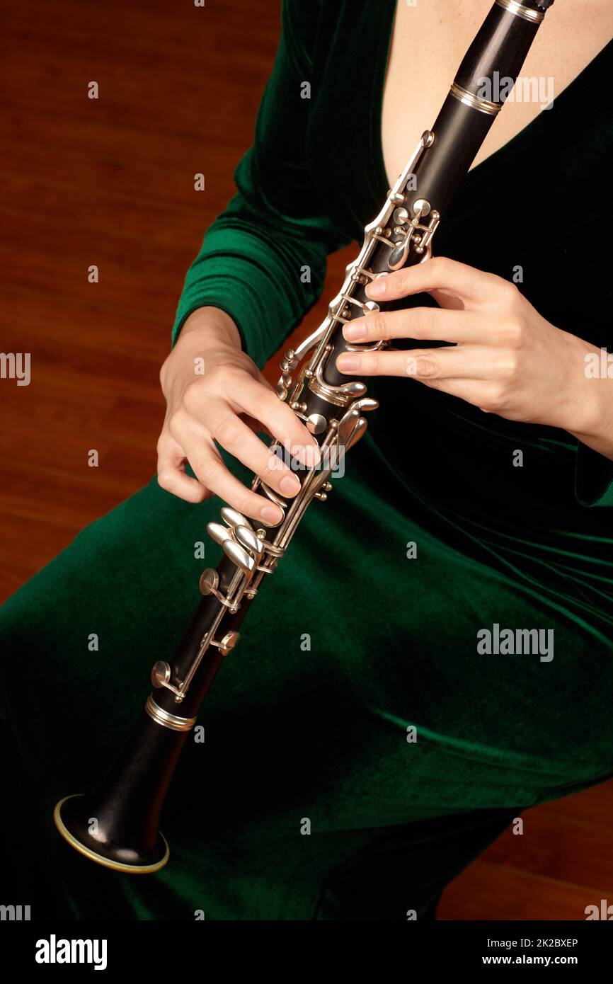 Das Wunder des Holzwindes. Ein zugeschnittenes Bild einer Frau, die eine Klarinette spielt. Stockfoto