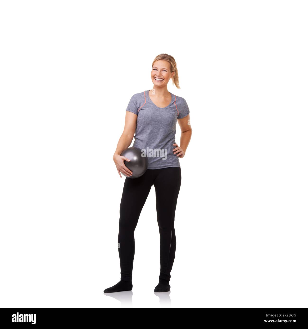 Wow dieser Ball machte den Unterschied. Eine hübsche junge Blondine, die nach einem belebenden Training einen Übungsball hält. Stockfoto