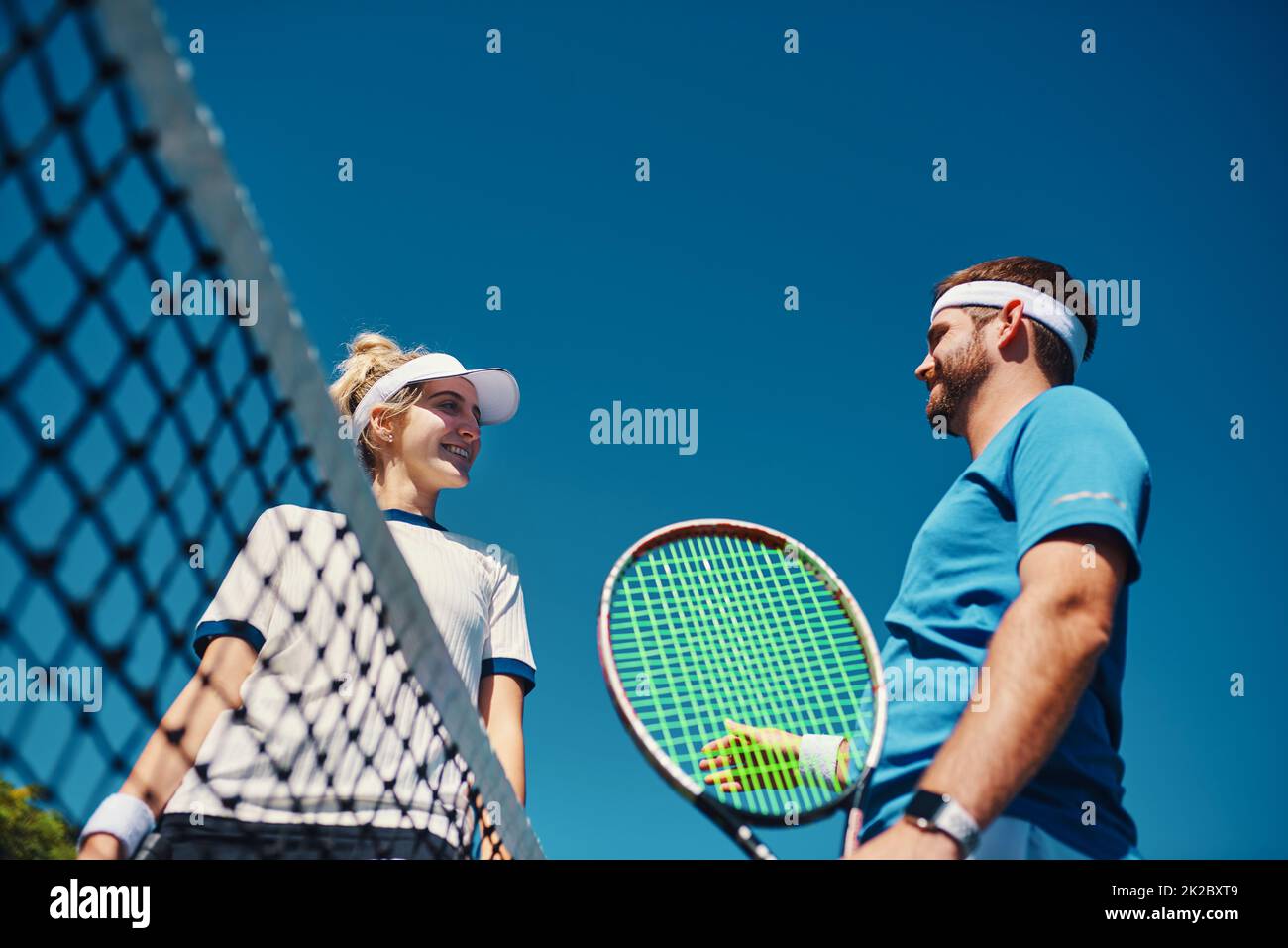 Mal sehen, was du bekommen hast. Low-Angle-Aufnahme zweier junger Tennisspieler, die sich draußen auf dem Platz unterhalten. Stockfoto