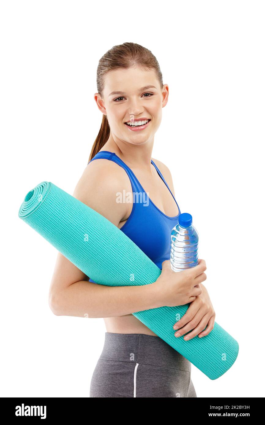 Sich Zeit nehmen, um Yoga zu machen. Ein hübsches Mädchen im Teenageralter mit einer Trainingsmatte und einer Wasserflasche. Stockfoto