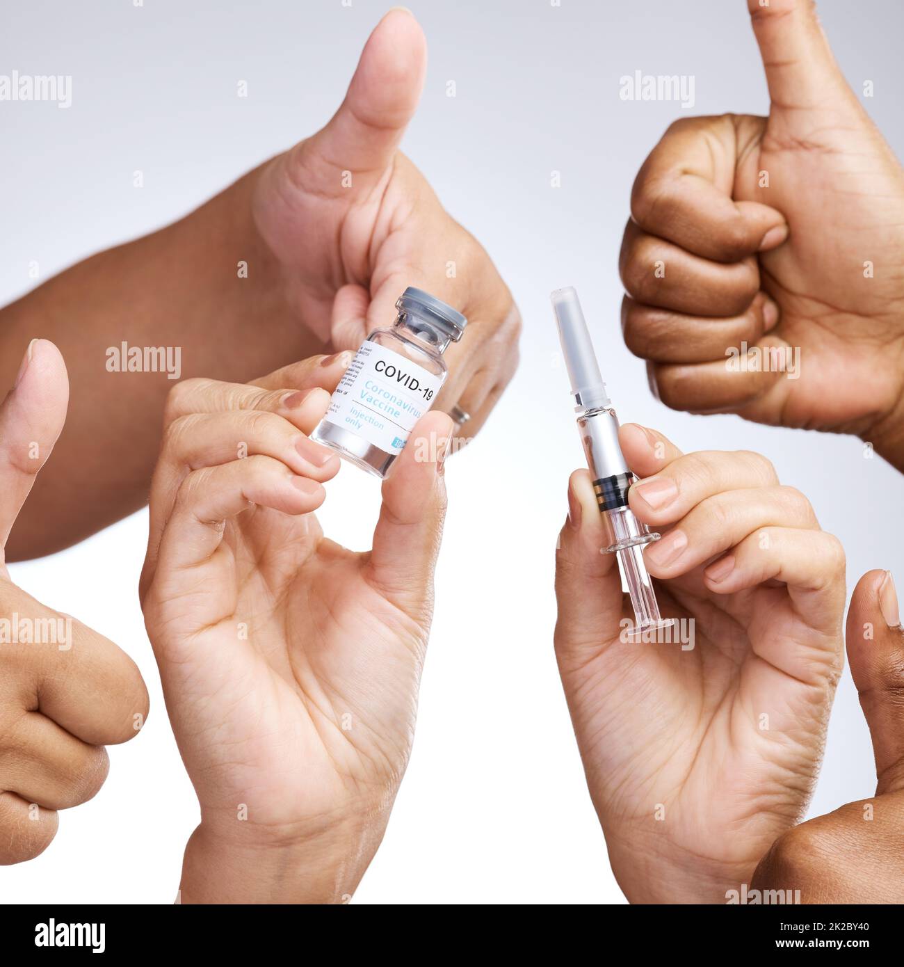 Sich selbst zu pflegen ist nicht egoistisch. Studioaufnahme einer Gruppe von Menschen, die Daumen nach oben zeigen und den Impfstoff vor grauem Hintergrund halten. Stockfoto