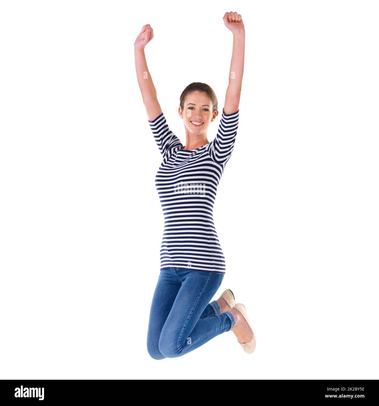 Springen vor Freude. Studioaufnahme einer ekstatischen jungen Frau, die isoliert auf Weiß in die Luft springt. Stockfoto