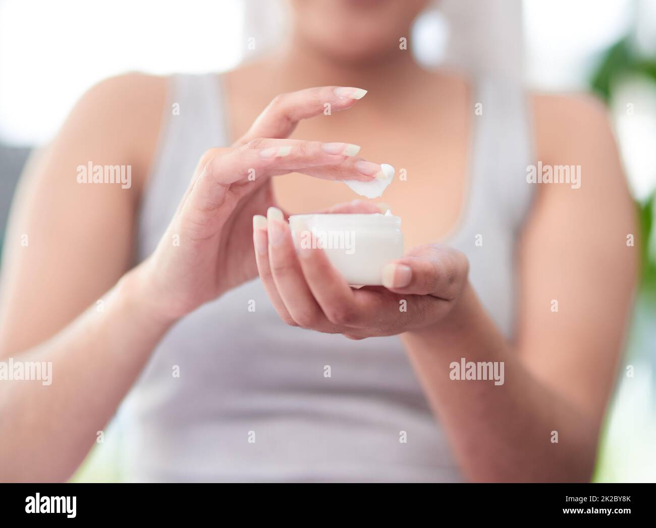 Spendet Feuchtigkeit für geschmeidige, glatte Haut. Schuss einer Frau mit einem Glas Creme. Stockfoto