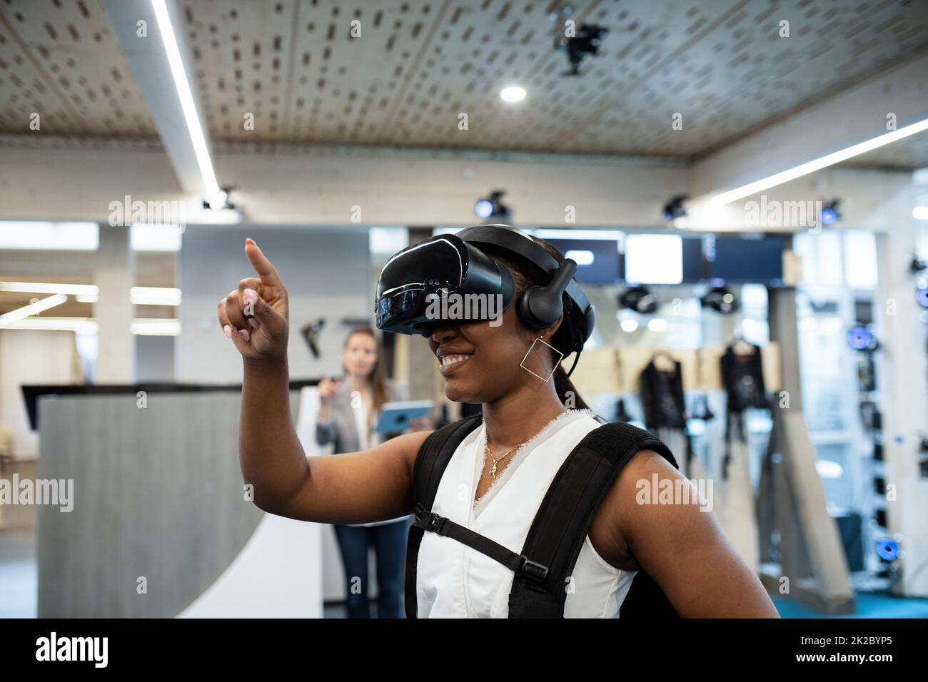Frau, die ein immersives Erlebnis mit VR-Kopfbedeckungen genießt Stockfoto