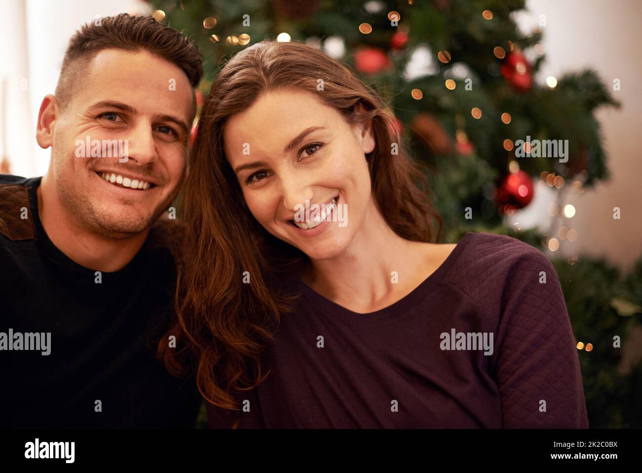 Unser erstes gemeinsames Weihnachtsfest. Porträt eines glücklichen jungen Paares am Weihnachtstag. Stockfoto
