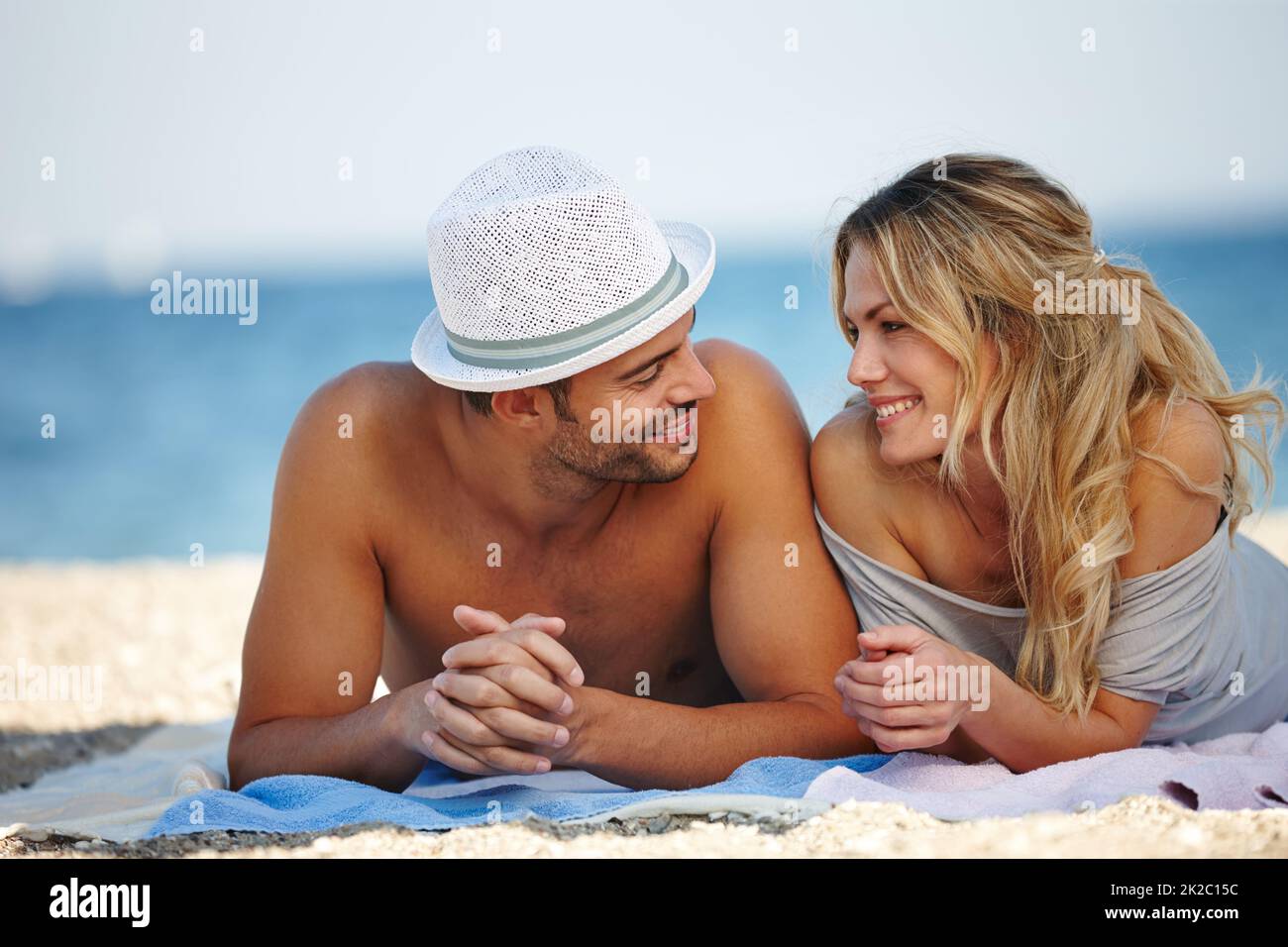 Romantik im Urlaub. Aufnahme eines glücklichen jungen Paares, das am Strand liegt. Stockfoto