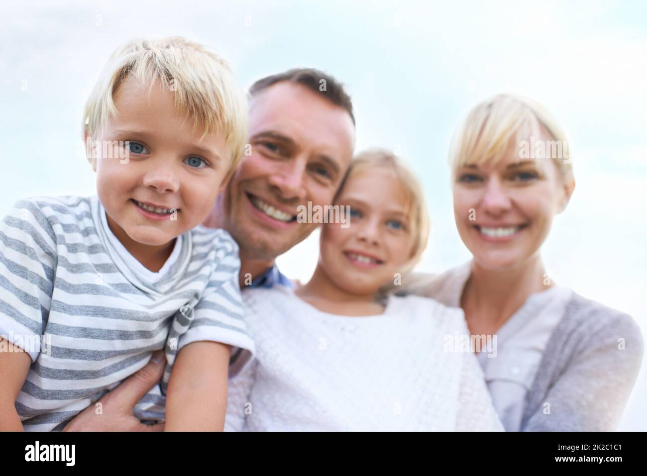Sie sind so eine glückliche Familie. Eine glückliche Familie in zwei Generationen, die im Freien lächelt. Stockfoto