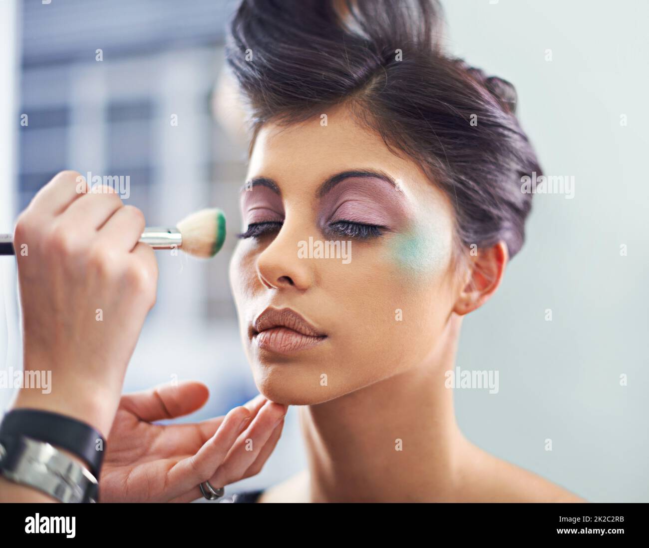 Ein Meisterwerk erschaffen. Eine junge Frau mit kosmetischen Verbesserungen, die Make-up aufgetragen hat. Stockfoto