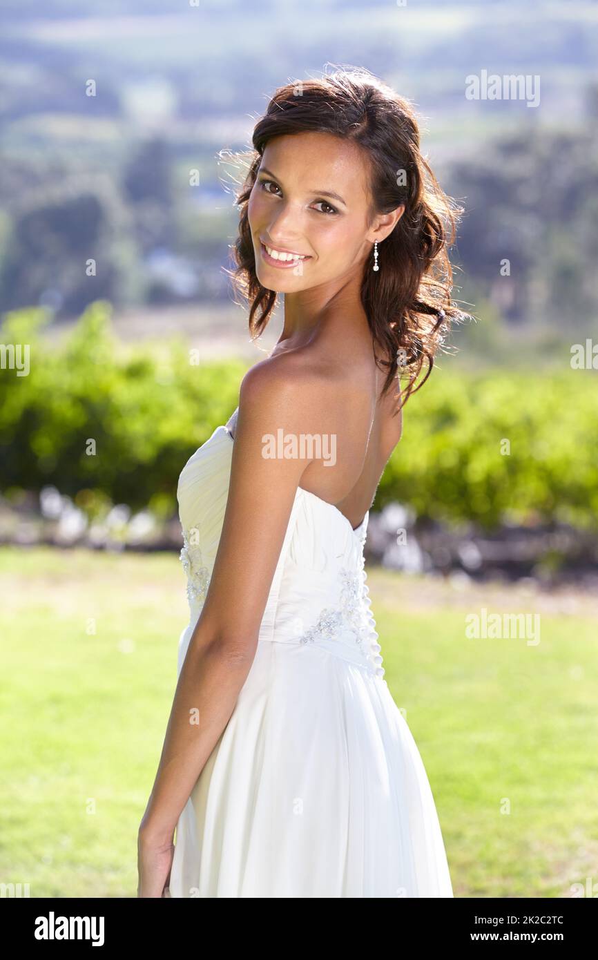 Sieht aus wie eine wahre Braut. Wunderschöne junge Braut im Freien in ihrem Hochzeitskleid. Stockfoto
