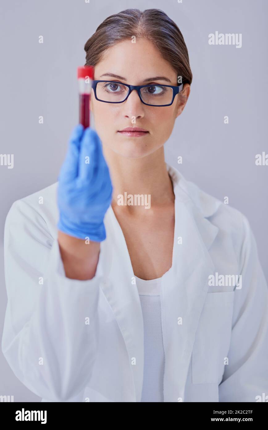 Sie hält den Schlüssel zur Heilung. Aufnahme eines Wissenschaftlers, der eine medizinische Probe untersucht, während er im Labor steht. Stockfoto