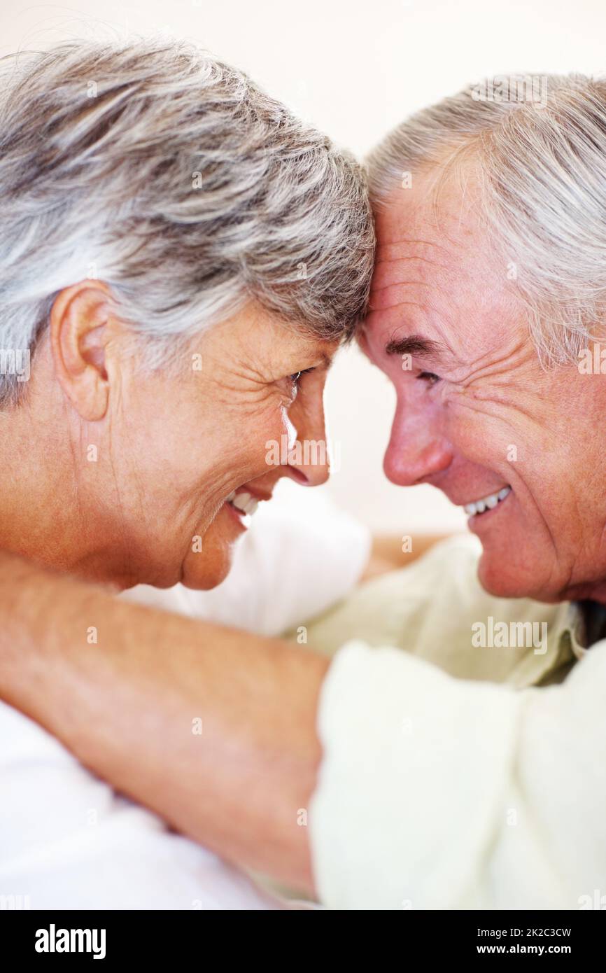Lächelndes reifes Paar, das sich ansieht. Nahaufnahme eines liebevollen, reifen Paares, das lächelt, während man sich von Kopf zu Kopf anschaut. Stockfoto