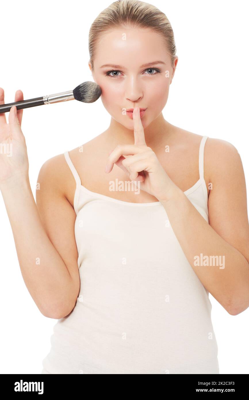 Das sind meine Schönheitsgeheimnisse Eine hübsche Frau, die einen Finger auf ihre Lippen legt, während sie ihr Gesicht errötete. Stockfoto