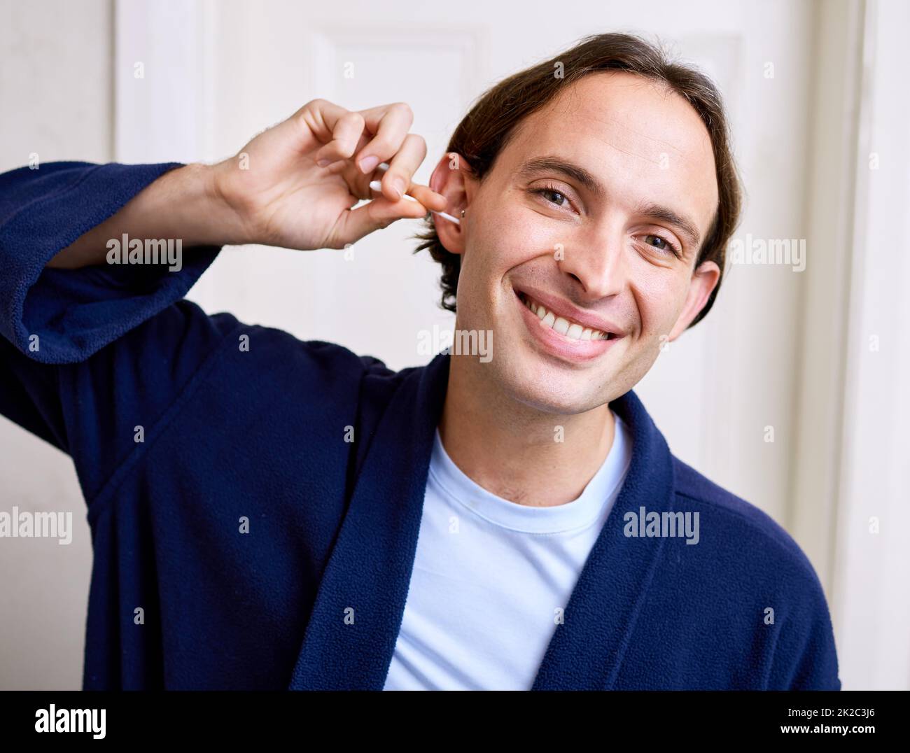 Sie sagen immer, dass sie keinen Ohrstöpsel verwenden sollen. Aufnahme eines jungen Mannes, der sein Ohr mit einem Ohrstöpsel reinigte. Stockfoto