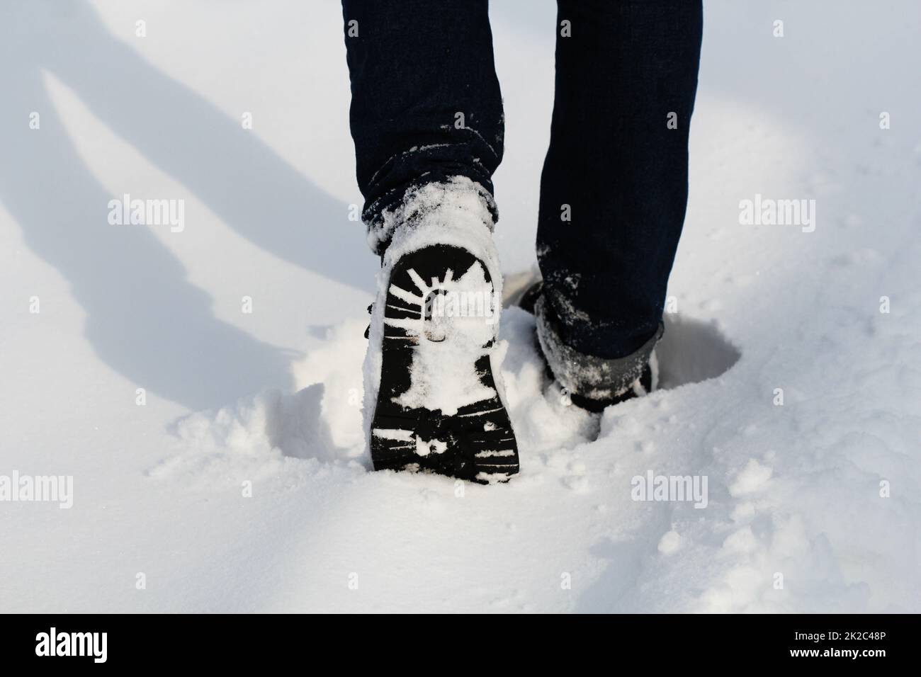 Männliche Beine im Winter Schuhe Wandern auf schneebedeckten Pfad. Close-up Stockfoto