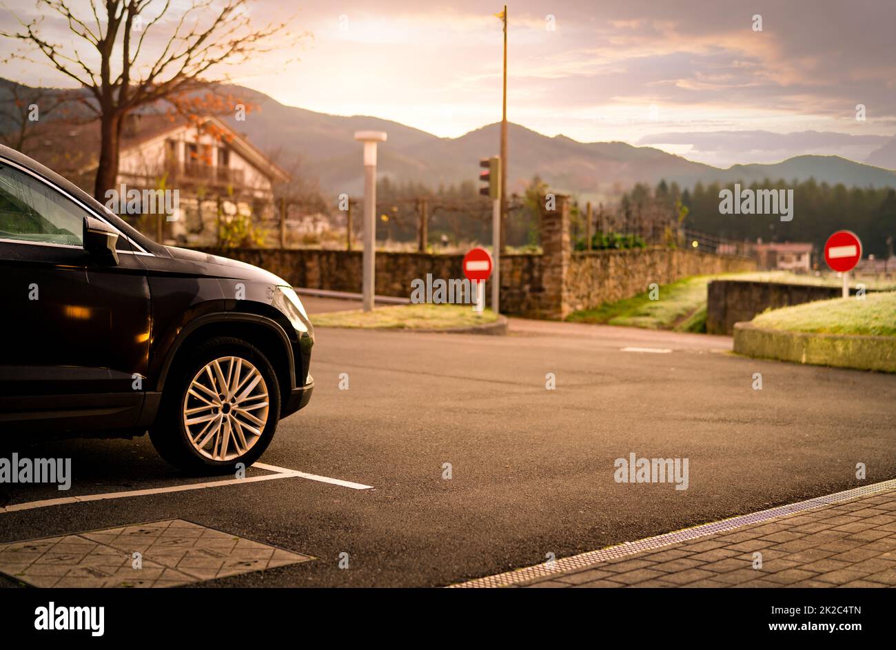 Schwarzes Auto auf dem Parkplatz des Hotels in Spanien. Parkplatz mit wunderschönem Blick auf die Berge. Roadtrip. Wetter am Morgen auf dem Parkplatz im Freien. In der Nähe des Naturlebens. Stockfoto