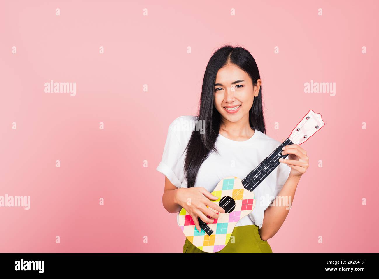 Frau Teenager selbstbewusstes lächelndes Gesicht mit akustischer Ukulele-Gitarre Stockfoto