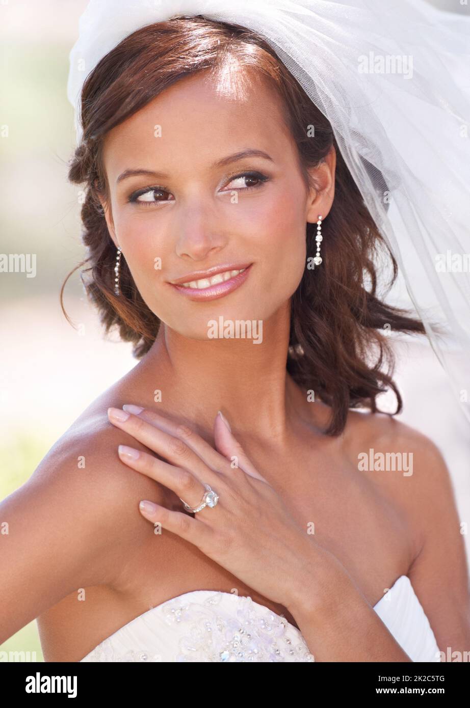 Strahlende Schönheit an ihrem Hochzeitstag. Eine wunderschöne junge Braut posiert im Freien. Stockfoto