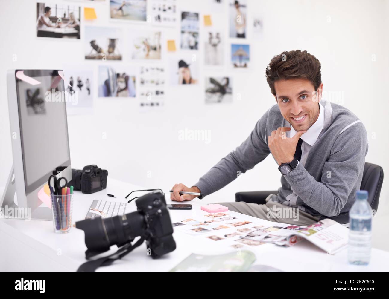 Seine endgültige Auswahl treffen. Ein Fotograf, der seine Bilder in seinem Büro ansieht. Stockfoto