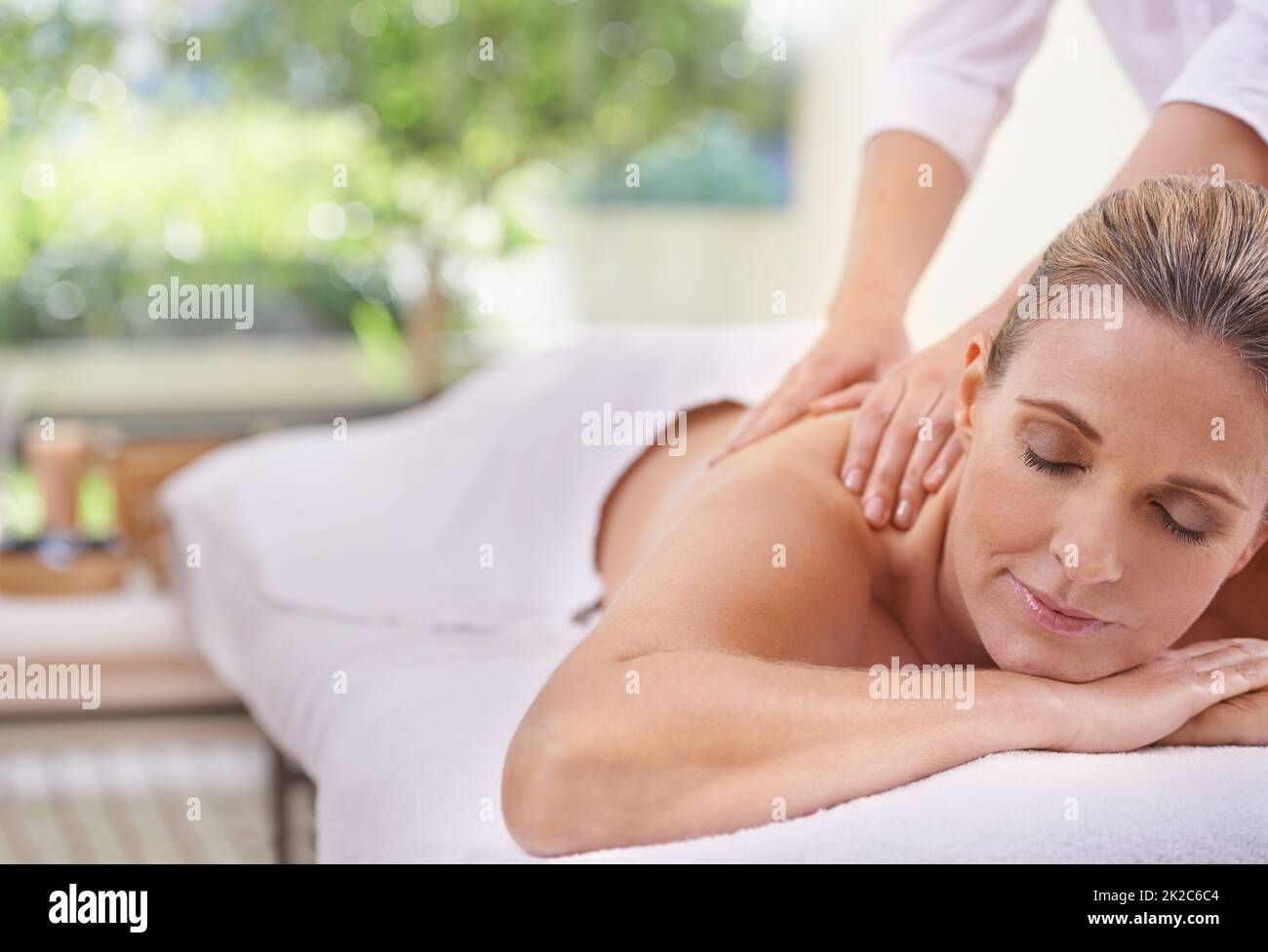 Die magischen Hände einer Masseuse. Eine kurze Aufnahme einer Frau in einem Day Spa, die sich auf einem Massagetisch entspannt. Stockfoto