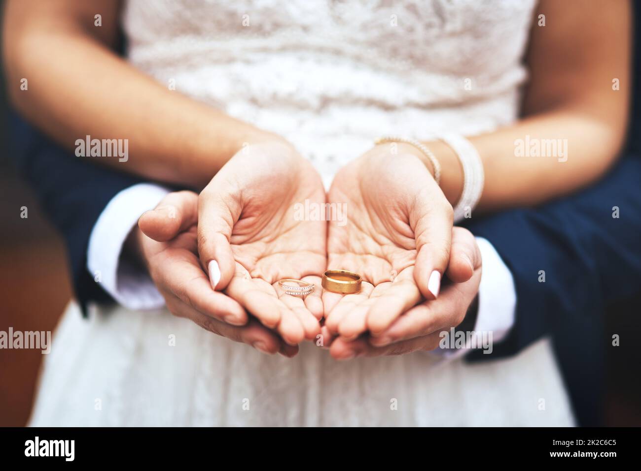 Das sind Symbole unserer Liebe und unseres Engagements. Ausgeschnittene Aufnahme eines unverkennbaren frisch vermählten Paares, das am Hochzeitstag ihre Ringe hält und zeigt. Stockfoto