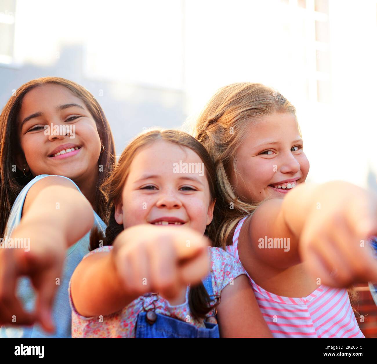 Es geht um Sie. Porträt einer Gruppe von kleinen Kindern, die nach draußen zeigen. Stockfoto