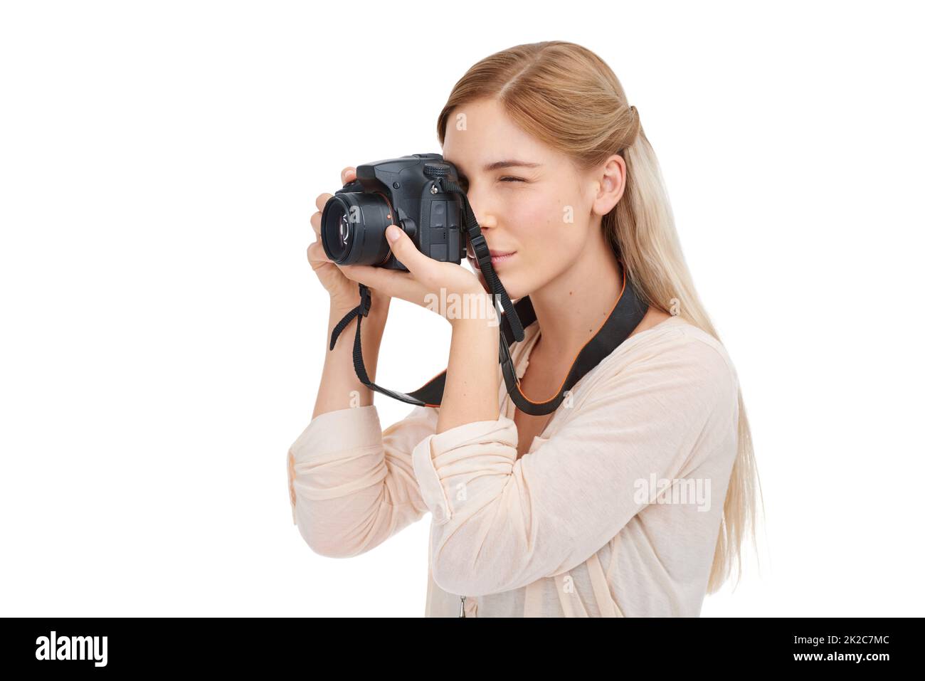 Leben durch das Objektiv. Studioaufnahme einer schönen jungen Frau, die mit ihrer Kamera vor weißem Hintergrund fotografiert. Stockfoto