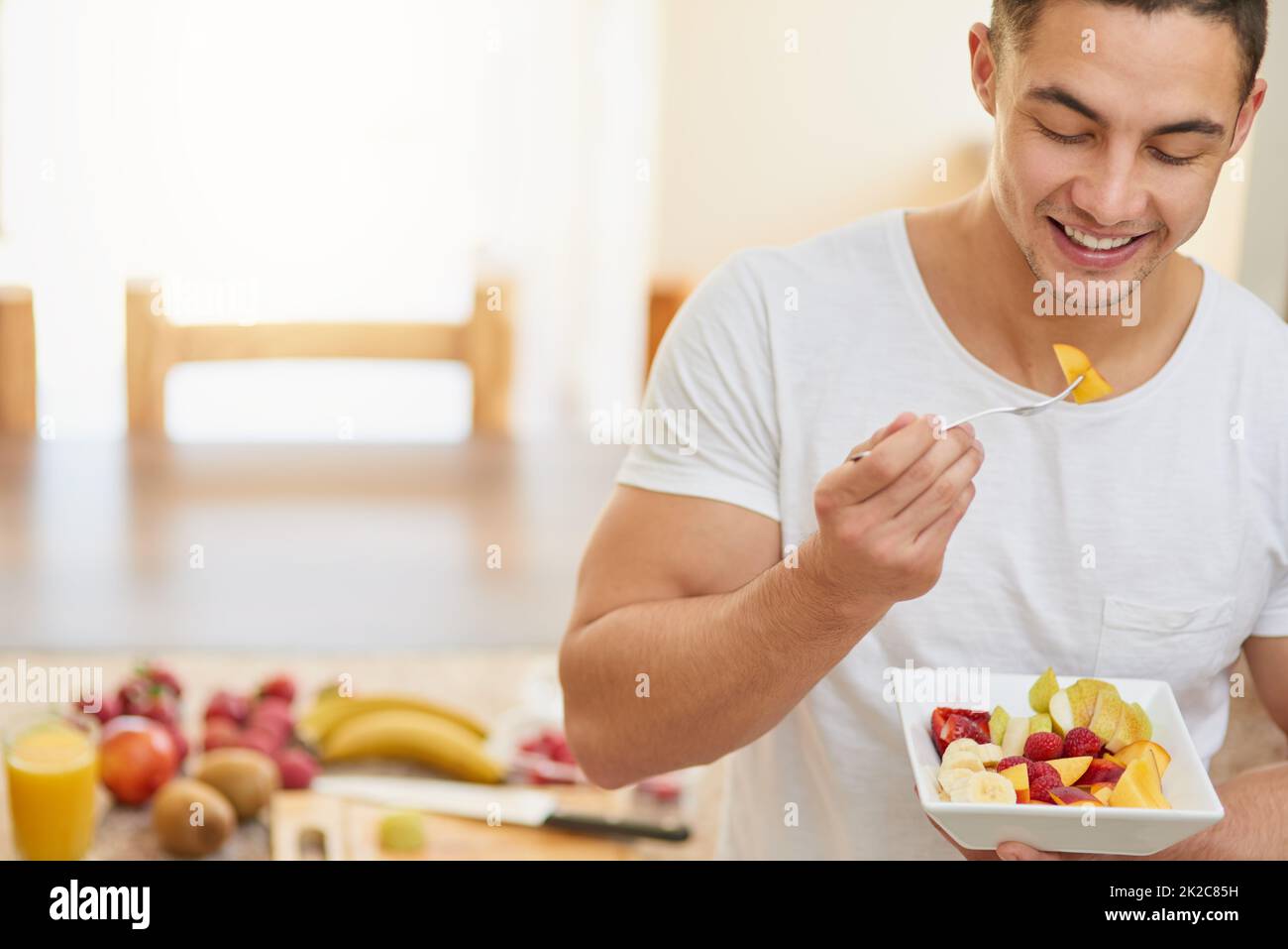 Nichts ist besser als zu einem gesunden Frühstück aufzuwachen. Kurzer Schuss eines jungen Mannes, der einen Obstsalat isst. Stockfoto