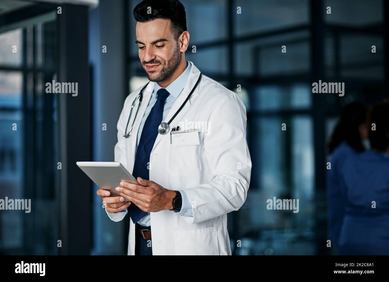 Buchen Sie eine Online-Beratung mit den medizinischen Bereichen am besten. Aufnahme eines jungen Arztes mit einem digitalen Tablet in einem Krankenhaus. Stockfoto
