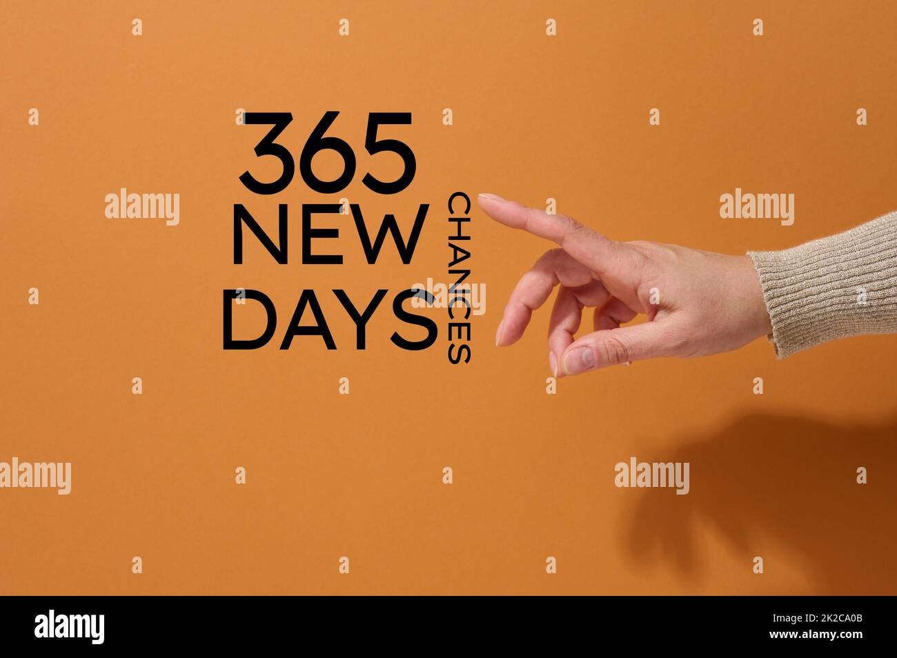 Weibliche Hand zeigt auf die Motivationsschrift 365 Tage sind 365 Chancen und neue Chancen. Das Konzept der Gründung eines neuen Lebens, eines neuen Geschäfts Stockfoto