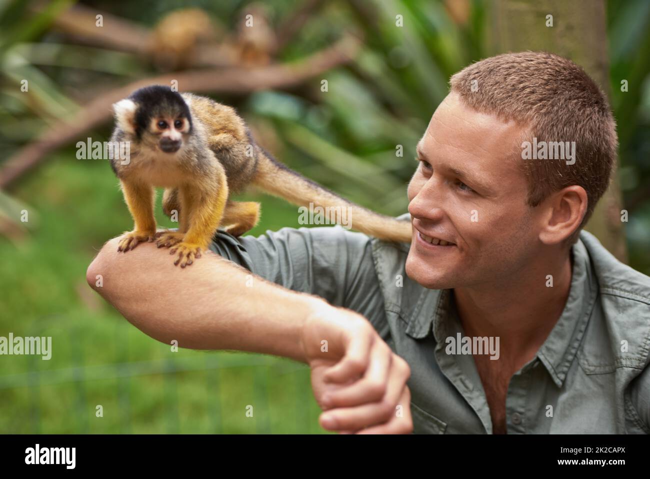 Tarzan liebte es, Zeit mit seinem kleinen Freund zu verbringen. Aufnahme eines jungen Mannes, der in einem Wildpark mit einem kleinen Affen interagiert. Stockfoto