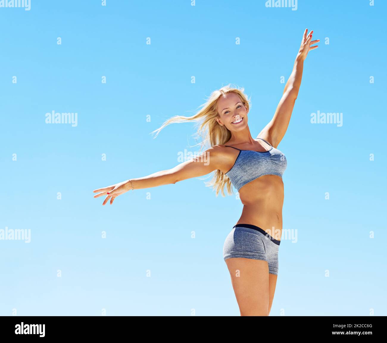 So perfekt wie das Wetter. Porträt einer jungen Frau in Trainingsausrüstung, die vor einem blauen Himmel steht. Stockfoto