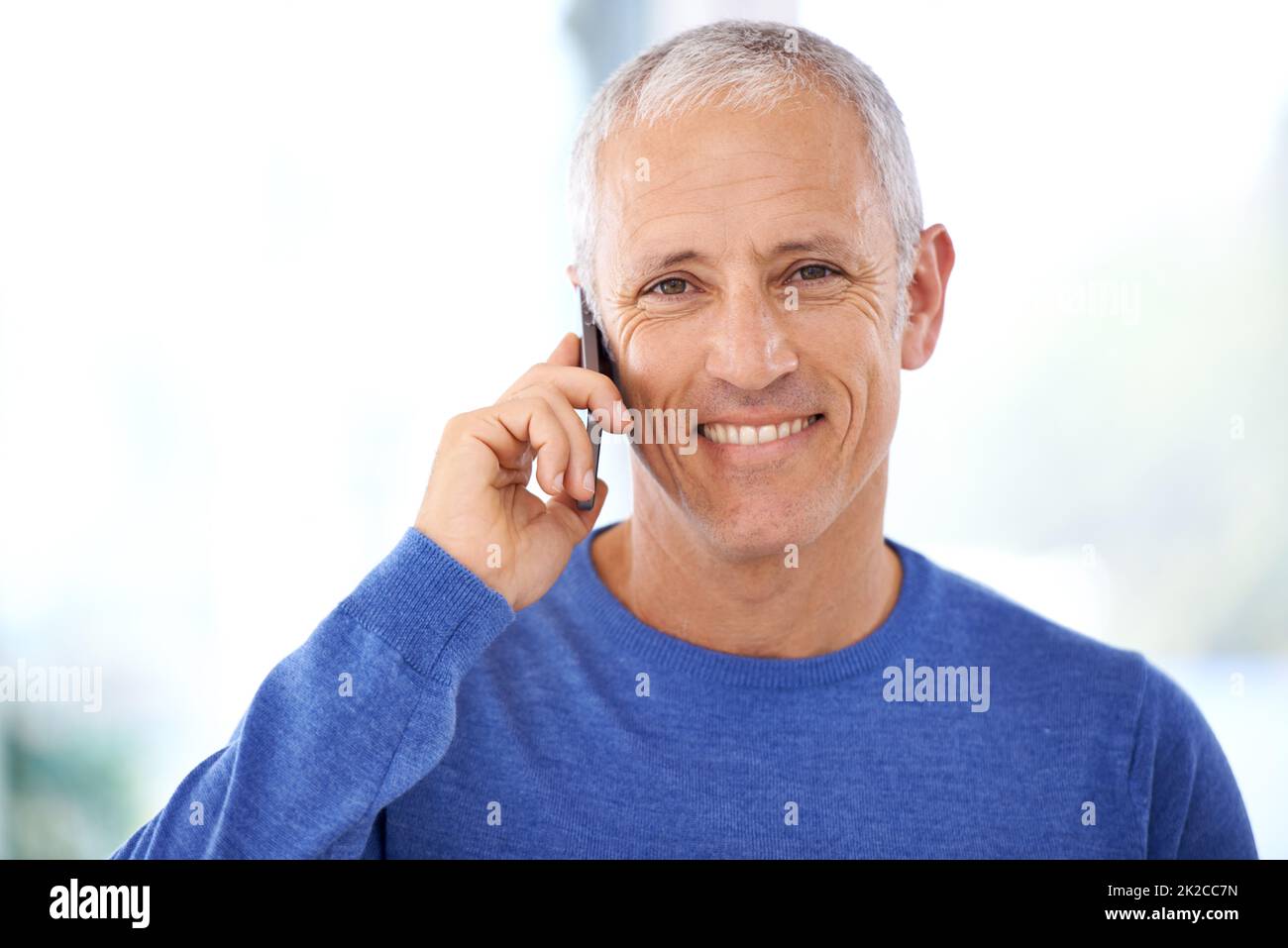 Mit Freunden und Familie in Kontakt bleiben. Ein reifer Mann, der ein angenehmes Telefongespräch führt. Stockfoto