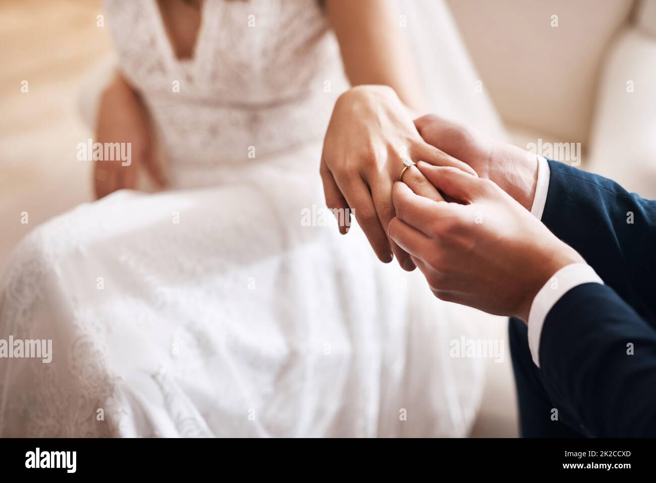 Heres to Forever. Ausgeschnittene Aufnahme eines unkenntlichen Bräutigams, der während der Hochzeit einen Diamantring auf den Finger seiner Frau legt. Stockfoto