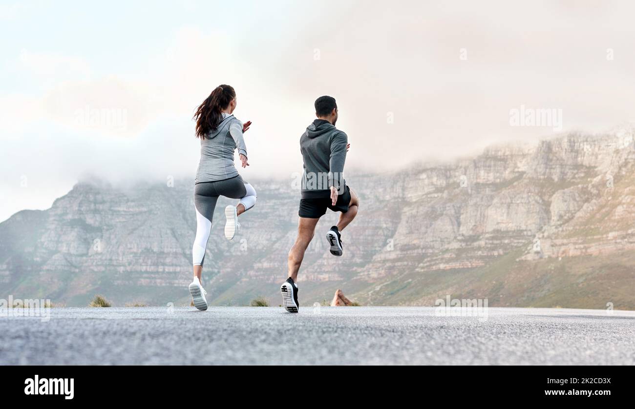 Stretching verbessert die Bewegungsfreiheit und lockert die Muskeln. Rückansicht eines sportlichen jungen Mannes und einer jungen Frau, die gemeinsam im Freien trainieren. Stockfoto