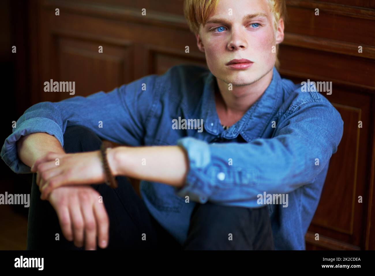 Brütende Jugend. Nachdenklicher und hübscher junger blonder Kerl mit sehr blauen Augen. Stockfoto