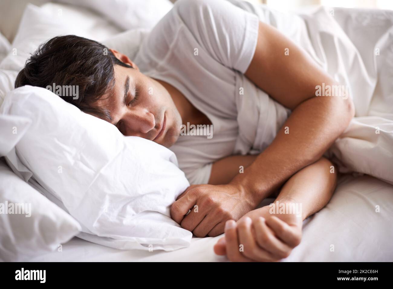 Süße Träume. Aufnahme eines jungen Mannes, der im Bett schläft. Stockfoto