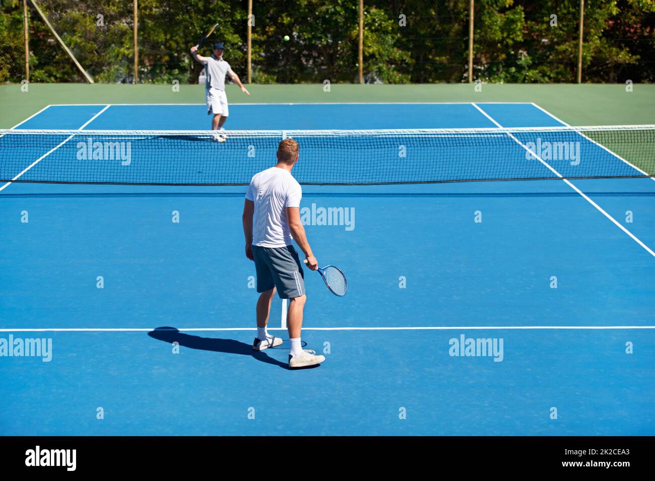 Das Spiel ist an. Menschen, die auf einem Tennisplatz Tennis spielen. Stockfoto
