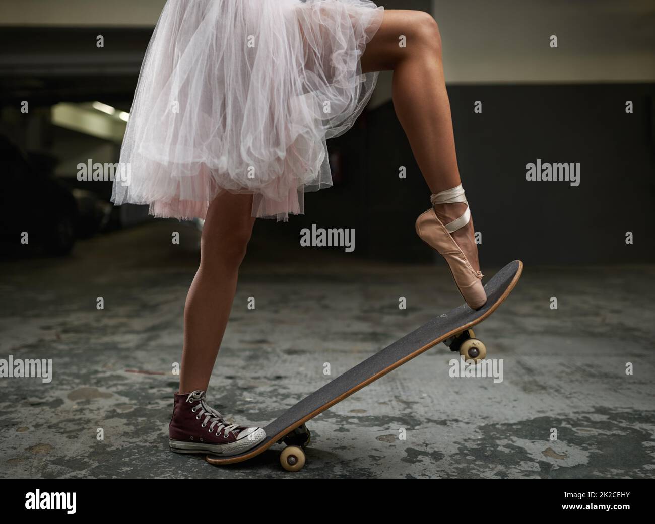 Ich habe viele Talente. Ein zugeschnittenes Bild einer Frau auf einem Skateboard, die einen Turnschuh und einen Ballettschuh trägt. Stockfoto