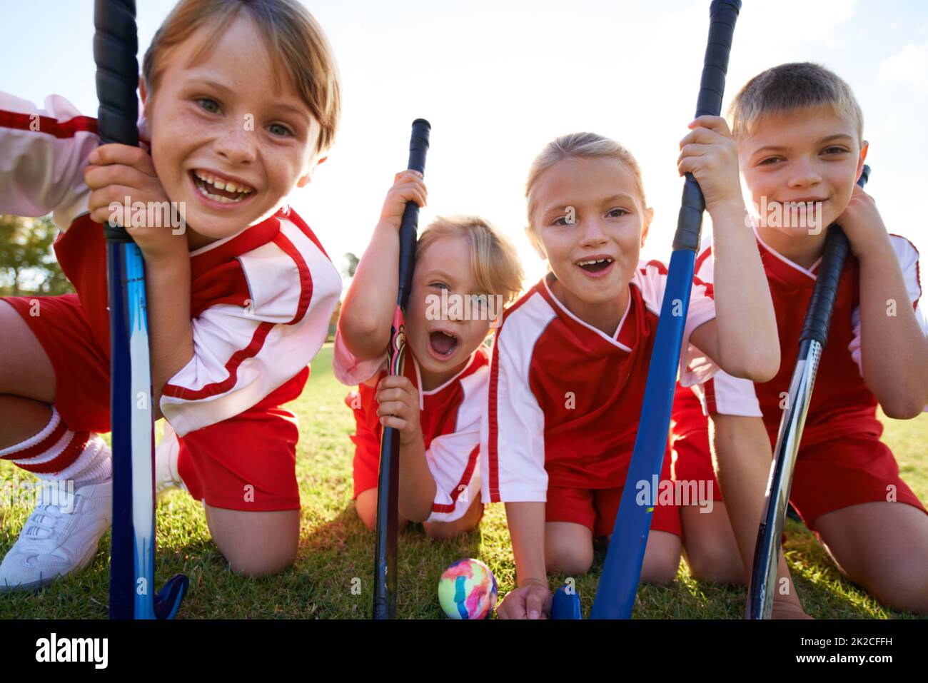 Sie haben einen starken Teamgeist. Porträt glücklicher Kinder, die Hockey spielen. Stockfoto