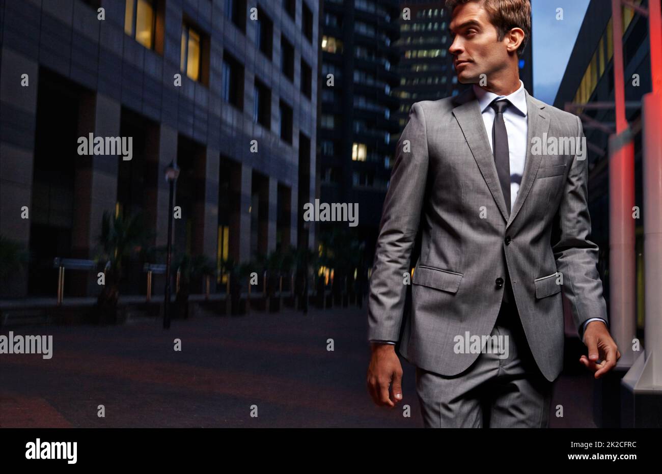 Durch die Stadt flitzen. Aufnahme eines gutaussehenden Geschäftsmannes in einem Anzug, der nachts durch die Stadt läuft. Stockfoto