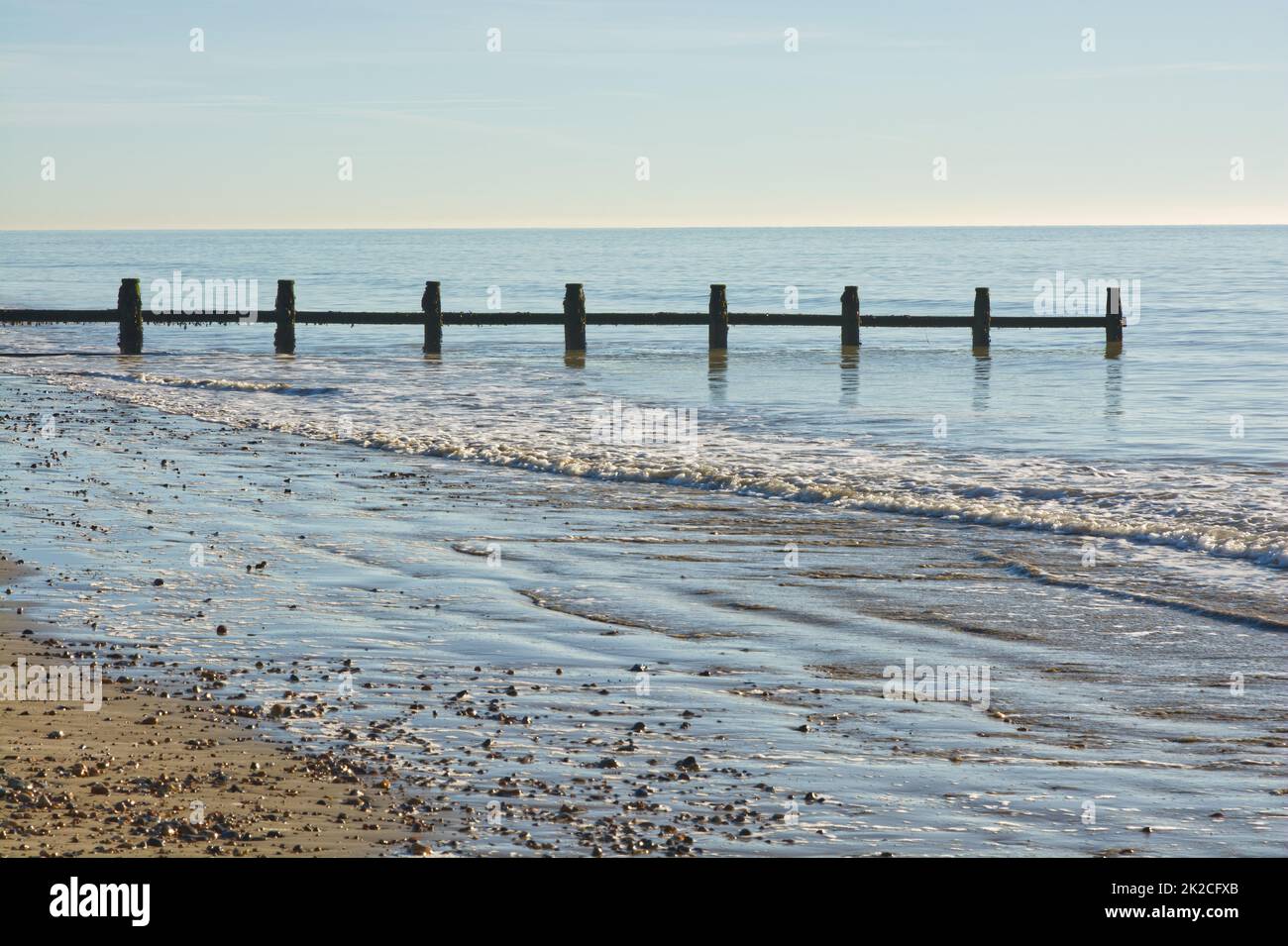 Ruhiges Meer mit Groyne und Strand Stockfoto