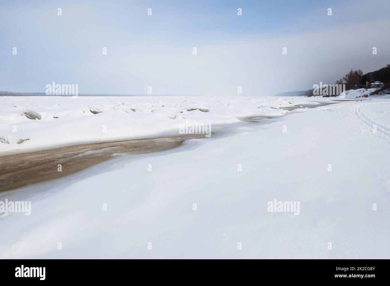 Atemberaubender Blick auf den gefrorenen Fluss bedeckt mit Eisstücken und weißem Frostschnee. Verschneite Wüste. Stockfoto