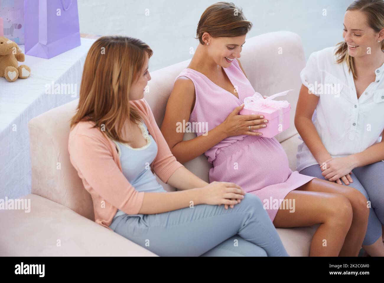 Was ist in der Box. Eine junge Schwangerin erhält Geschenke für ihr kleines Mädchen an der Babydusche. Stockfoto