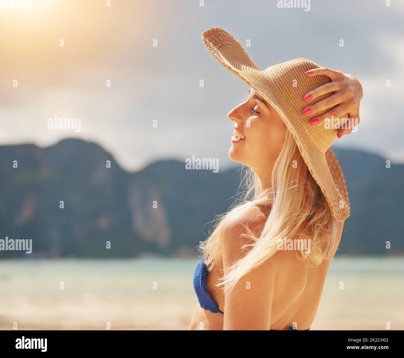 Genießen Sie die Sonne. Aufnahme einer glücklichen jungen Frau in einem Bikini, der sich an einem tropischen Strand entspannt. Stockfoto