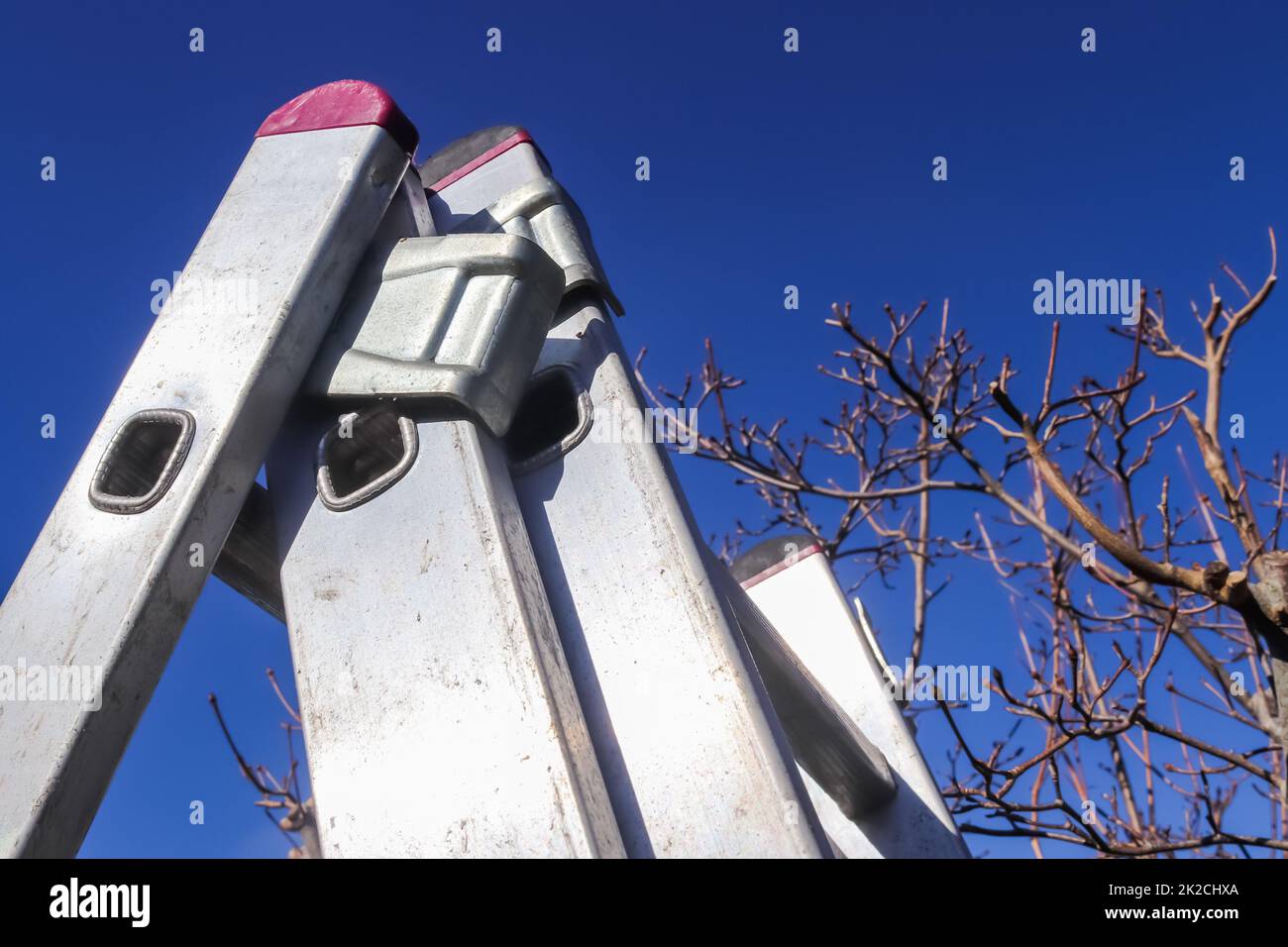 Die Oberseite einer Aluminiumleiter am blauen Himmel. Stockfoto