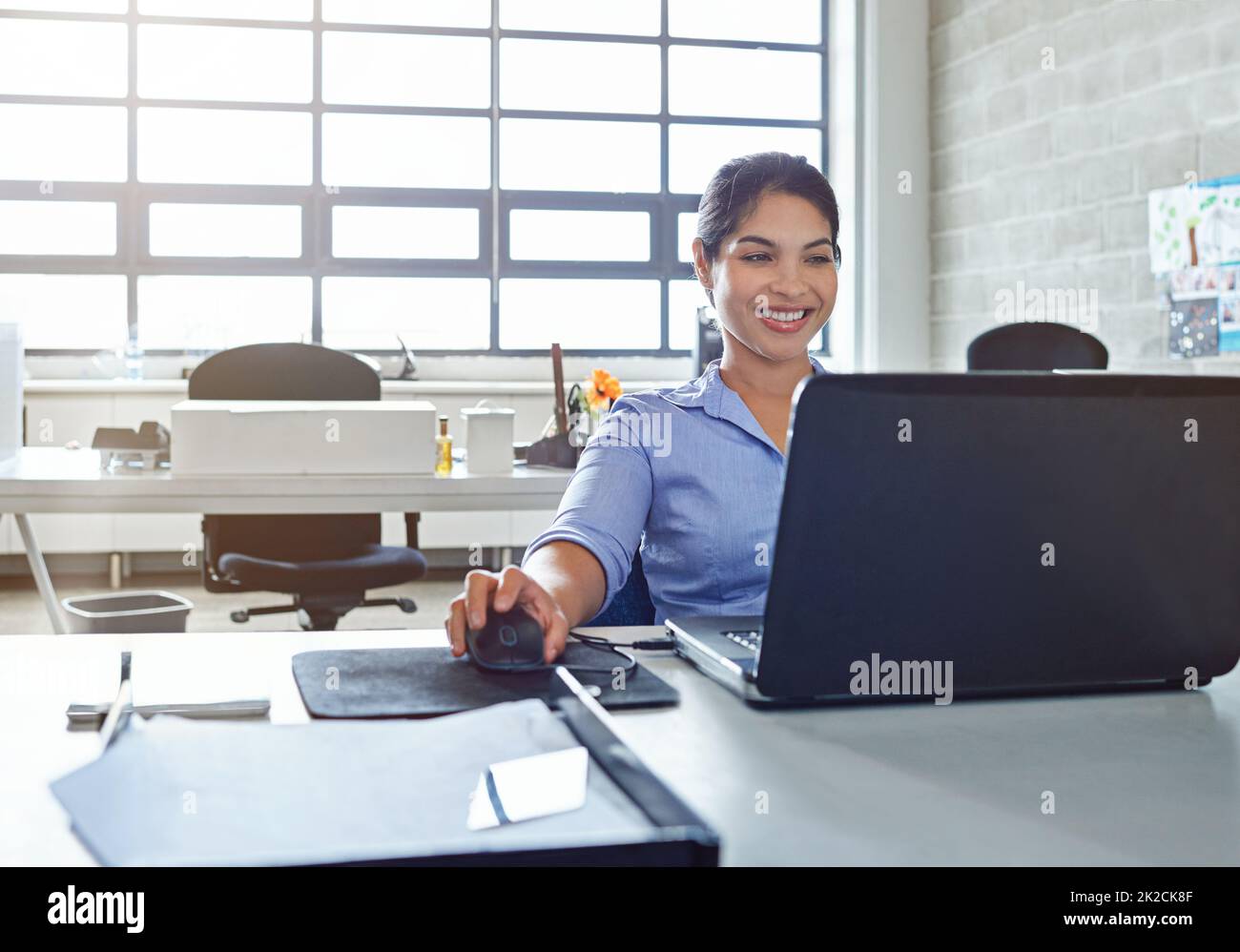 Das Lächeln, das aus einer erfolgreichen Karriere kommt. Aufnahme einer jungen Geschäftsfrau, die bei der Arbeit einen Laptop benutzt. Stockfoto