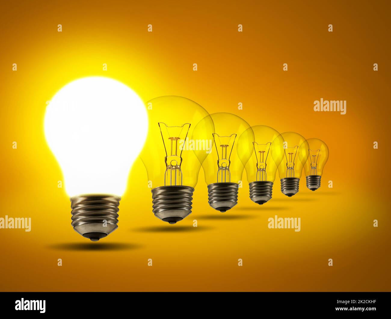 Setzen Sie Ihre Ideen an die erste Stelle. Studioaufnahme einer Reihe von Glühbirnen vor einem orangen Hintergrund. Stockfoto