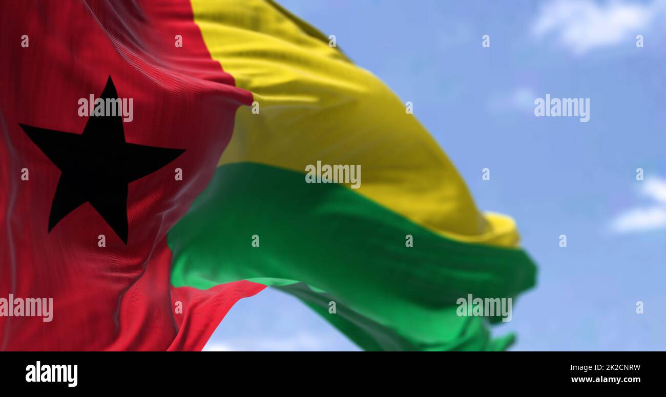 Detail der Nationalflagge von Guinea-Bissau, die an einem klaren Tag im Wind winkt. Stockfoto